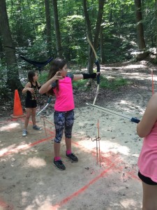 Aiva Nolan learns how to use a bow and arrow during archery.