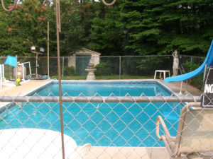 A swimming pool behind a house